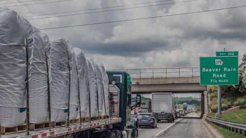 A photo of a wide highway with traffic clogged on it and a green sign that says Beaver Ruin Road.