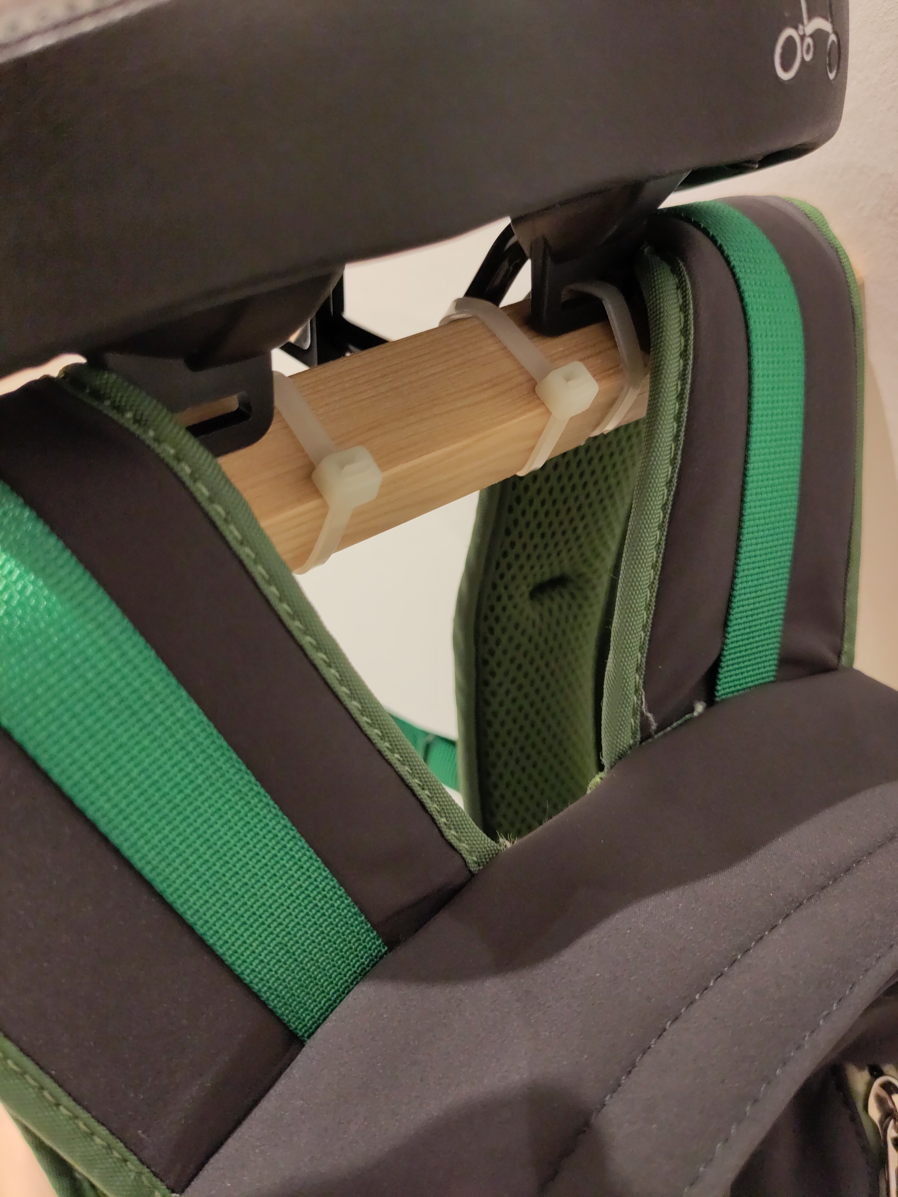 Wooden rod attached to underside of Brompton Backpack and backpack shoulder straps layed over