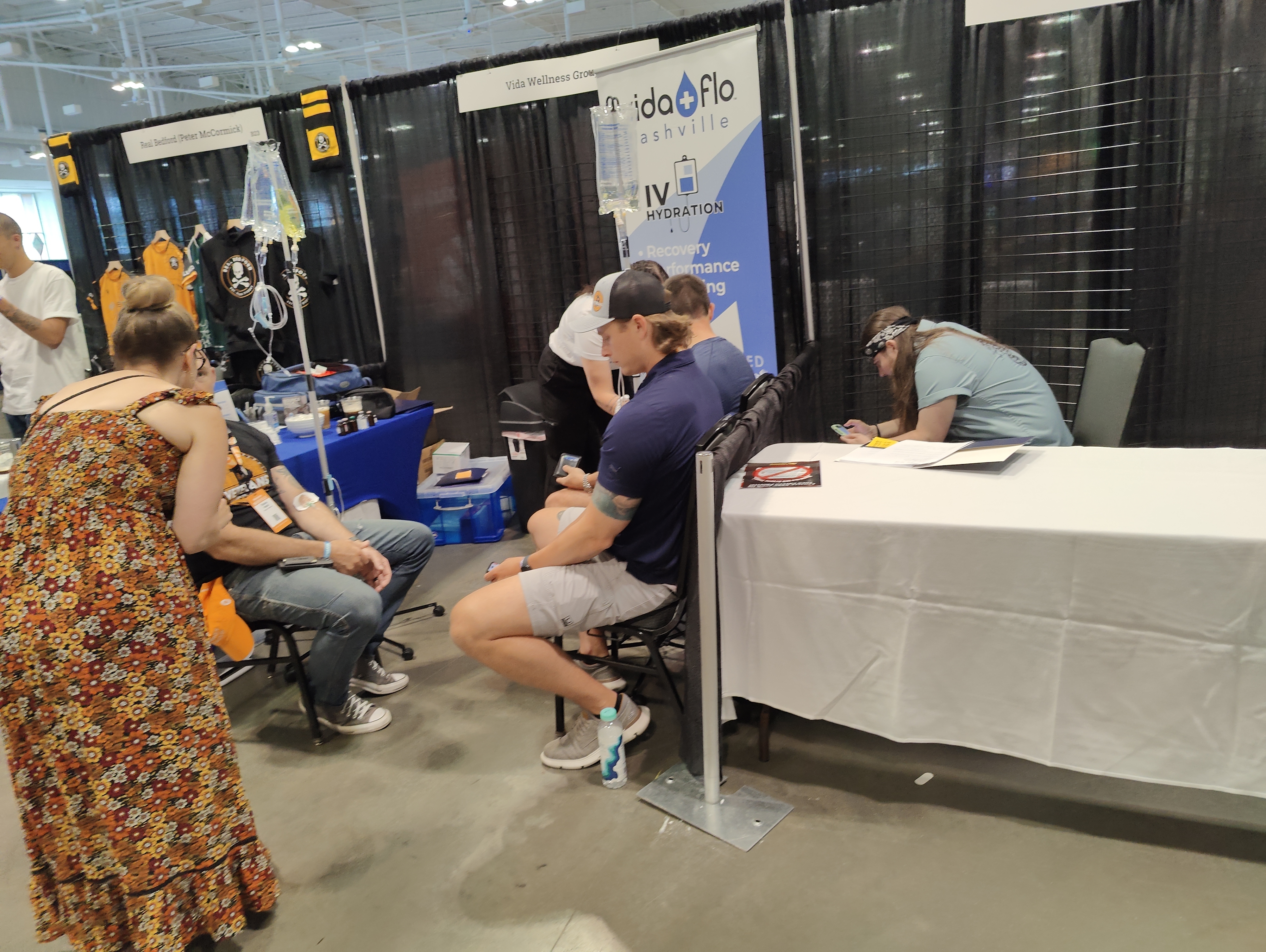 Men hooked up to IV's at a convention booth