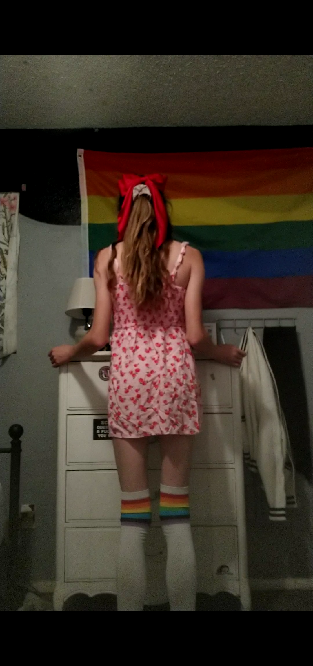 me wearing pink dress and red bow in my hair. facing away from camera