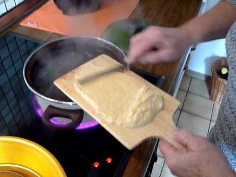 still from video with spätzle board and knife poised over a pot of boiling water