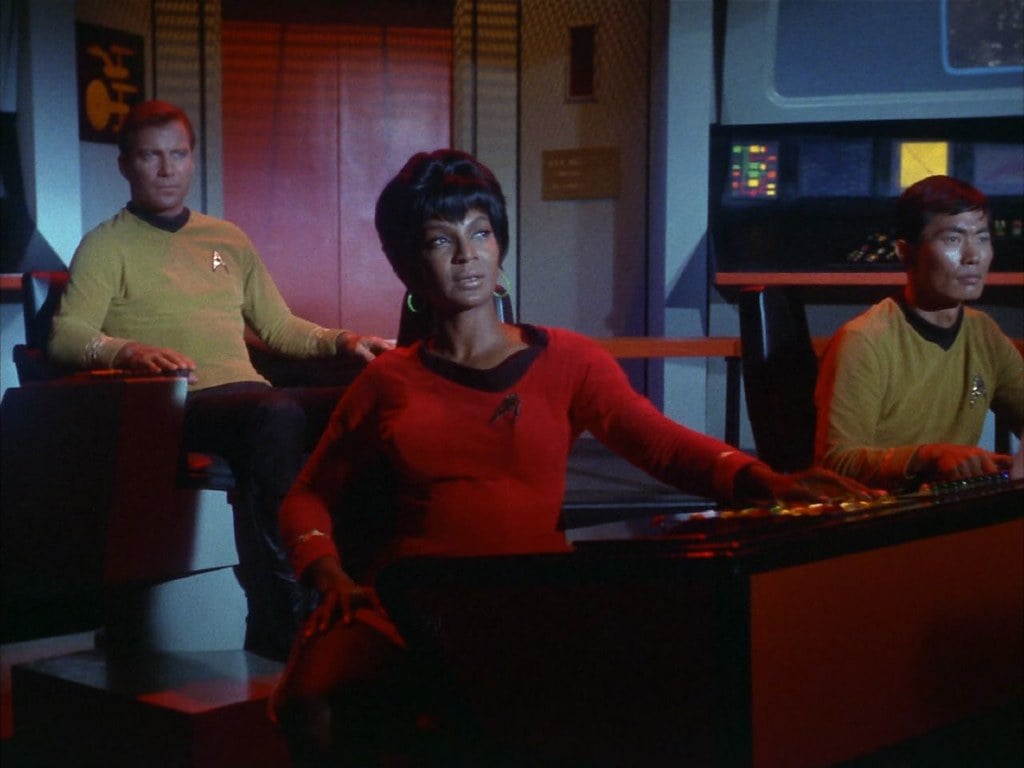 Lieutenant Uhura, sitting at the Navigation console, watching the Romulan ship explode on the viewscreen along with Lieutenant Sulu and Captain Kirk at their respective stations.