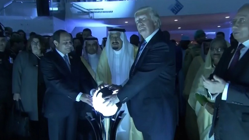 A photo of Trump, Saudi King Salman bin Abdulaziz, and Egyptian President Abdel Fattah el-Sisi holding a creepy glowing orb in a darkened room in Saudi Arabia