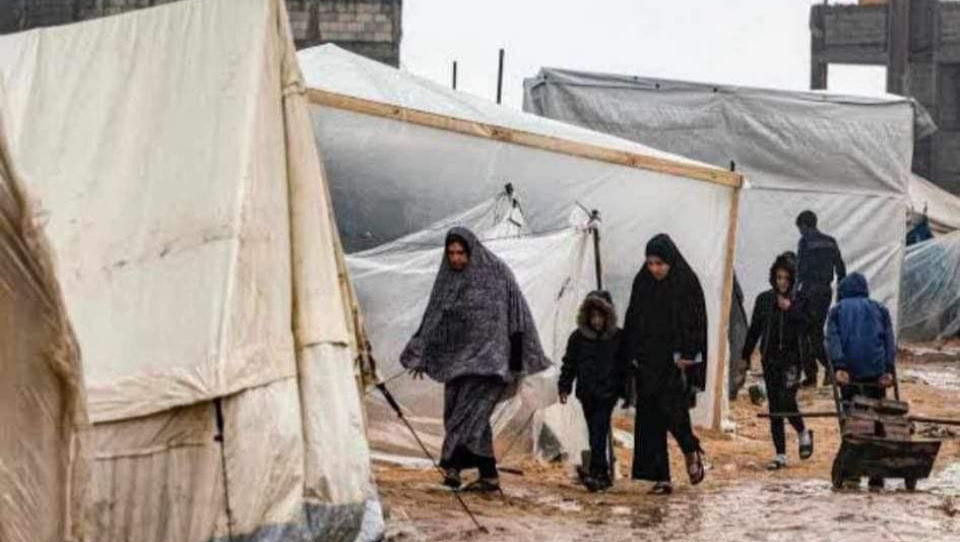 A picture of a group of people, presumably his family, walking in the refugee camp. 