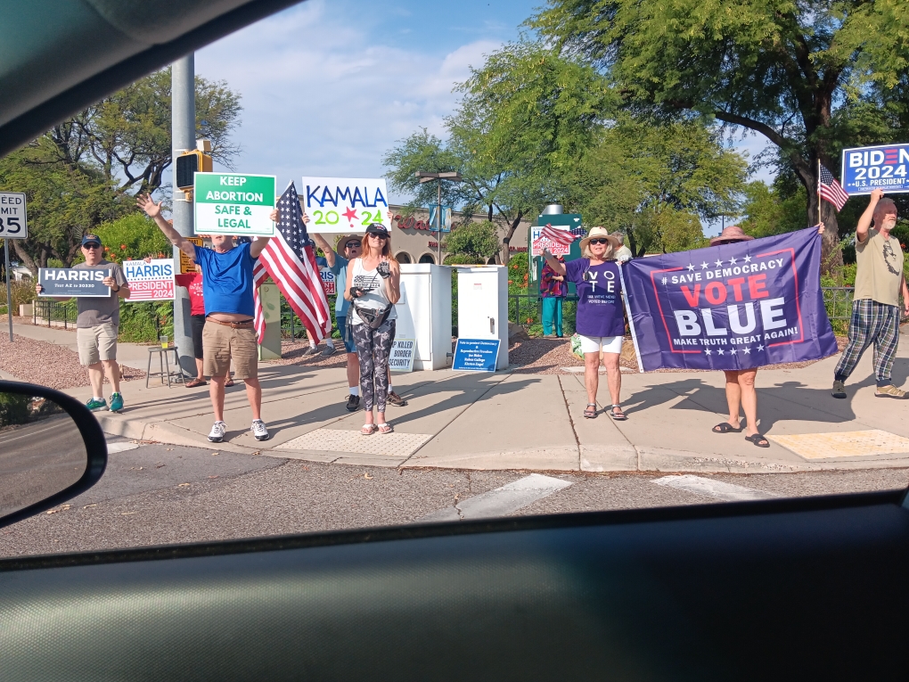 A group of enthusiastic people holding signs in support of Kamala Harris for President in Green Valley